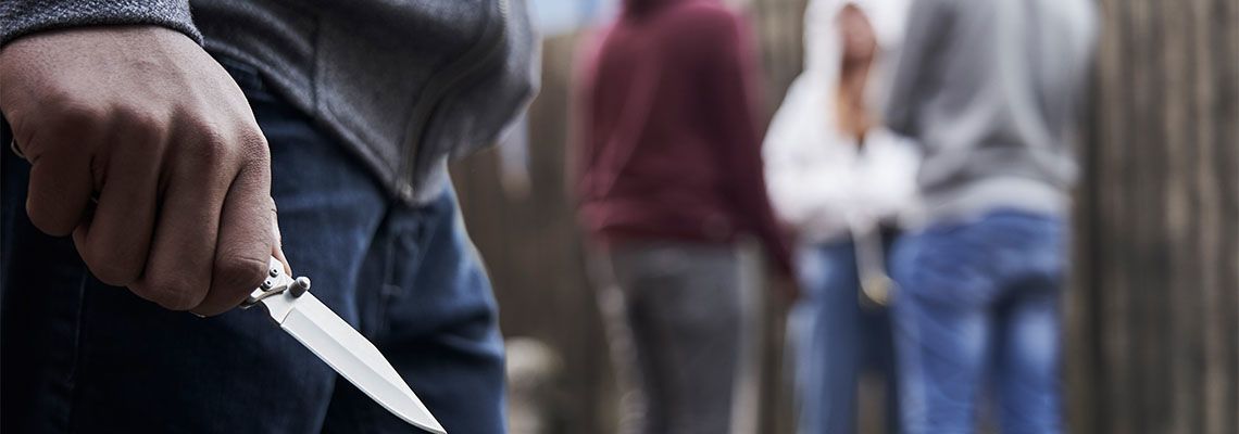 Teenage Boy In Urban Gang Holding Knife