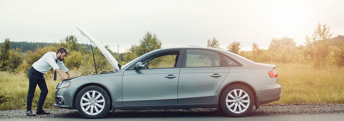 Man with broken down car in road