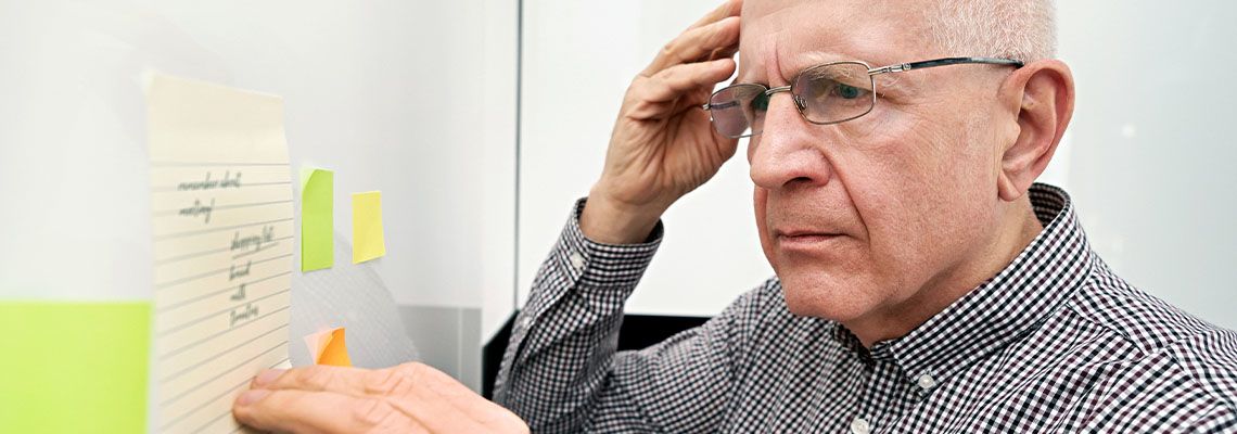 Elderly man with dementia looking at notes