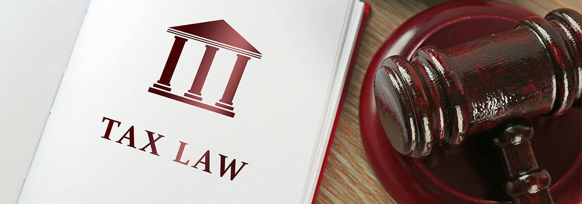 Open book with words tax law and gavel