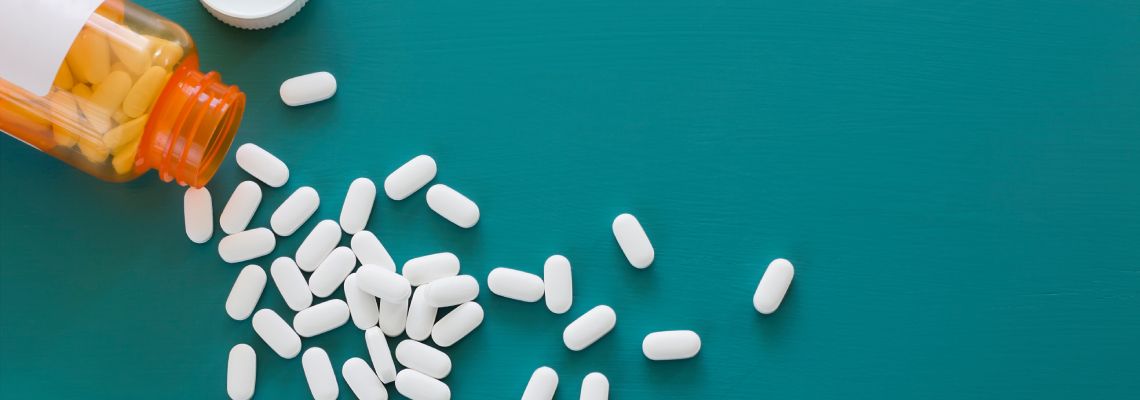 White Prescription Pills on teal background