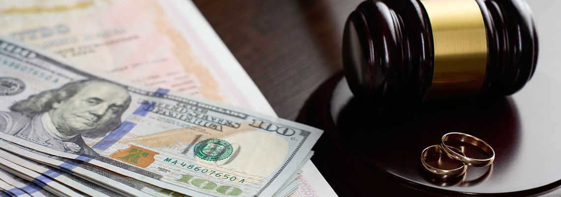 Alimony money, Gavel and Wedding ring in table.