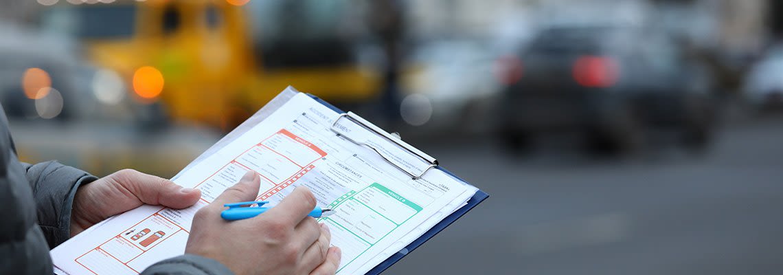 A man fills out a car accident report