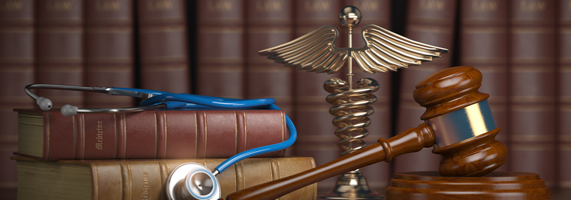 Gavel, Stethoscope and Caduceus Sign on Books Background