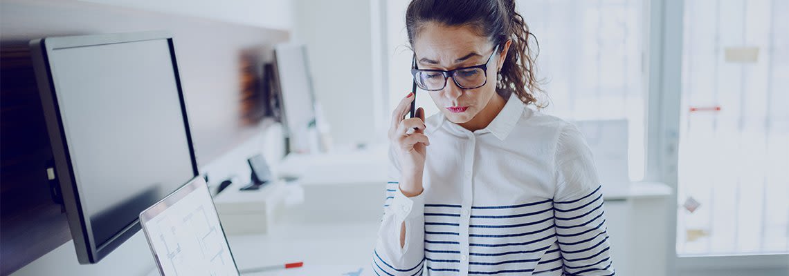 Person talking on phone in front of computer