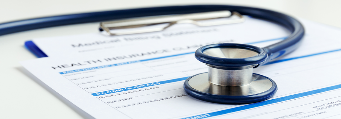 Stethoscope on health insurance form on table