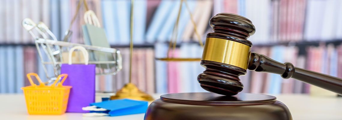 Gavel with miniature shopping carts and product bags