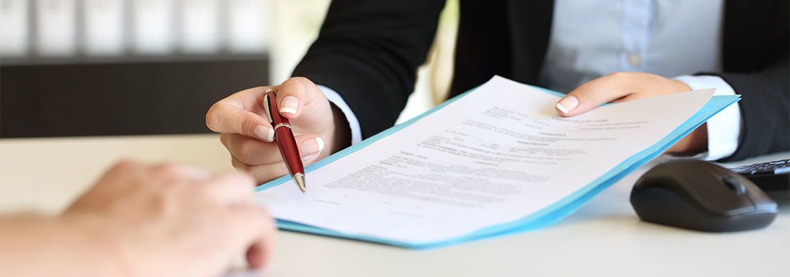 HR manager handing contract document to employee for signing