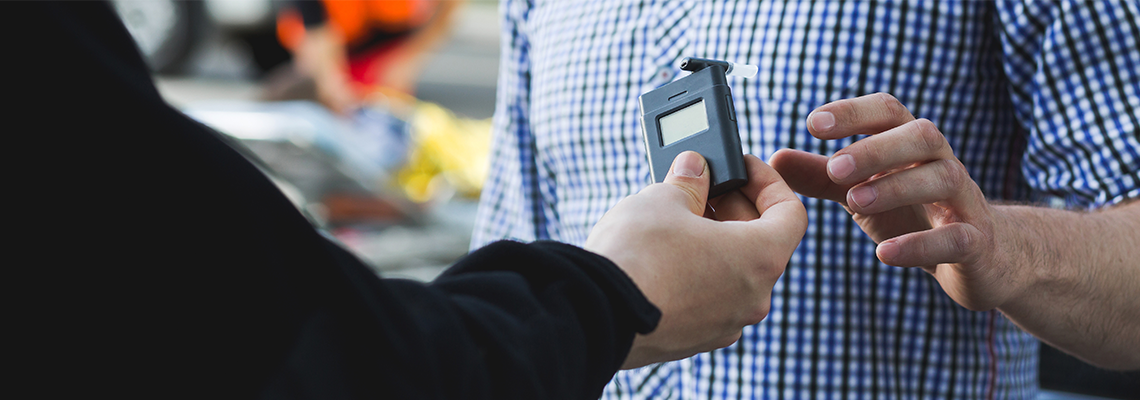 Policeman Giving a Breathalyzer to A Driver