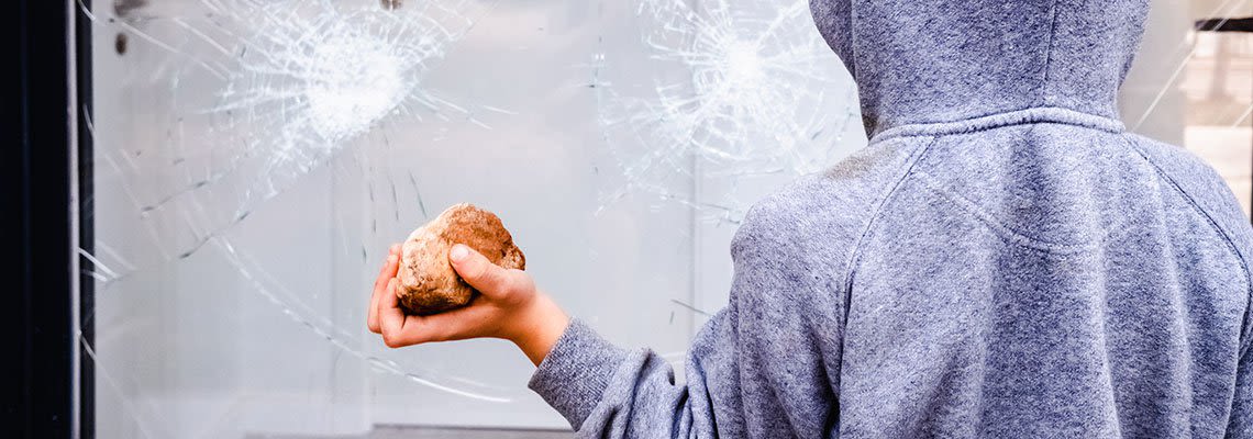 A child throws rocks at a window