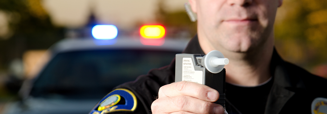 Police officer holding breathalyzer