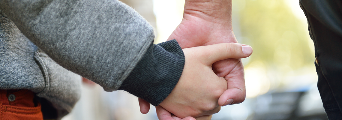 Person holding child's hand