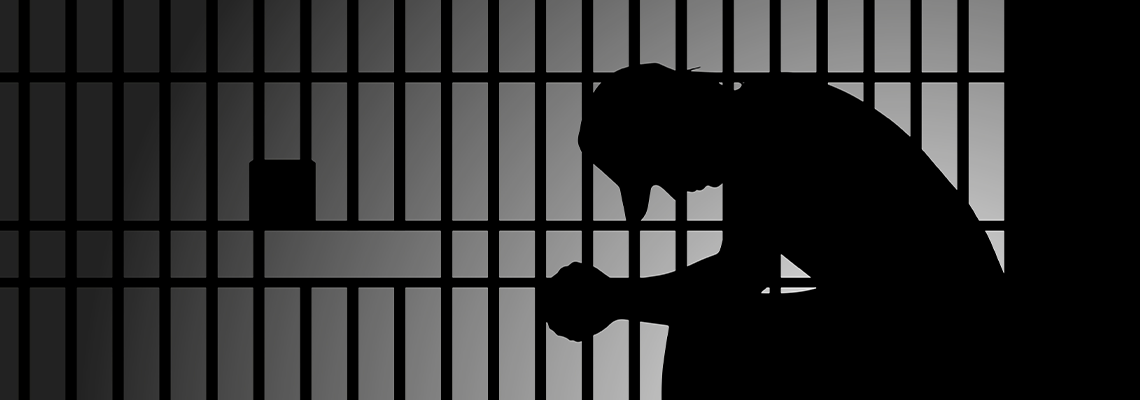 Person sitting down next to steel bars