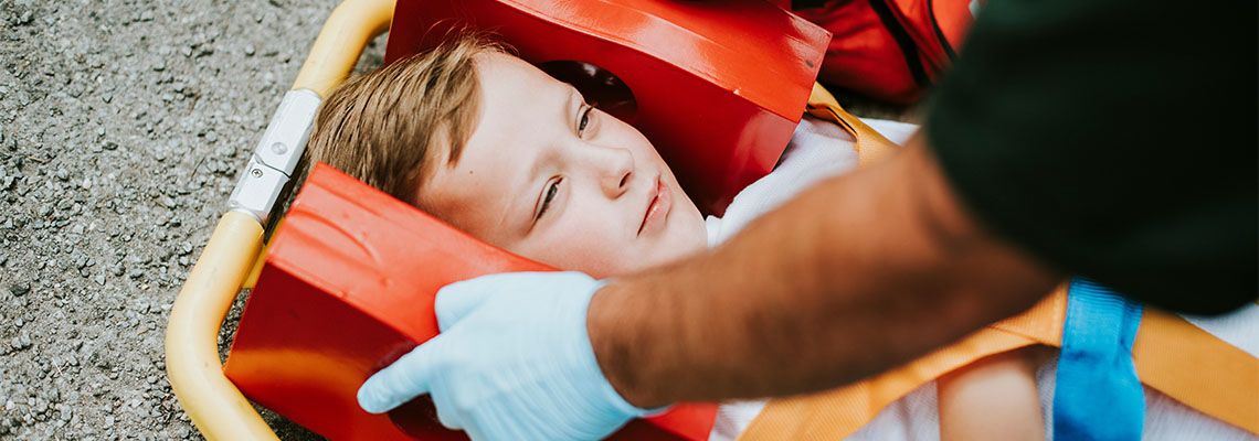 Young injured boy lying on an ambulance stretcher