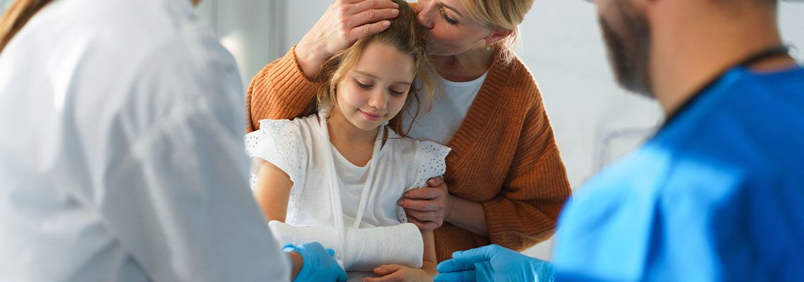 Doctor treating little girl with broken arm