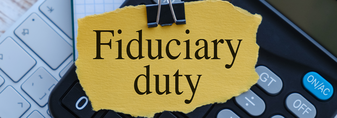 Fiduciary Duty text on yellow paper on calculator With keyboard on wooden background