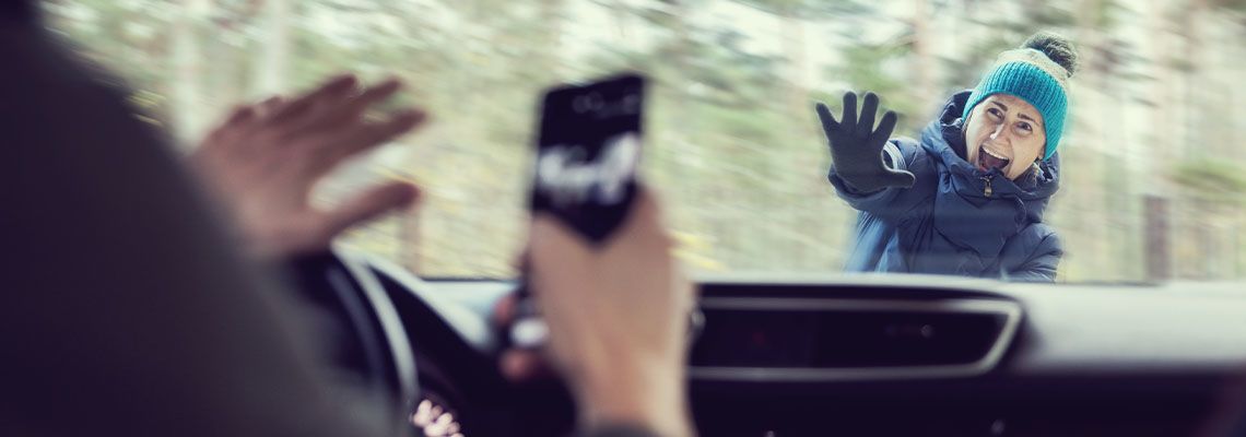 Distracted driver on phone about to collide with pedestrian