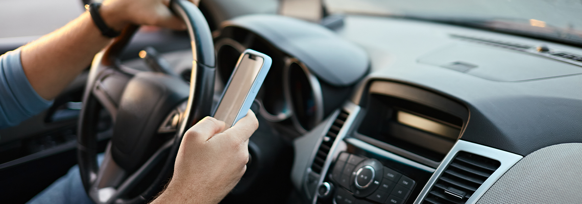 Hands of unrecognizable man driver using mobile phone while driving