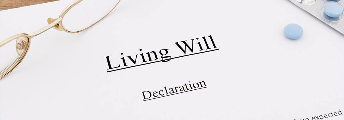Living will with pills and eyeglasses on wooden table