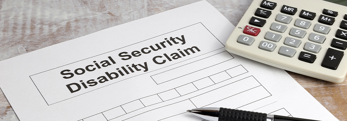 Disability claim form social security desk with calculator and pen