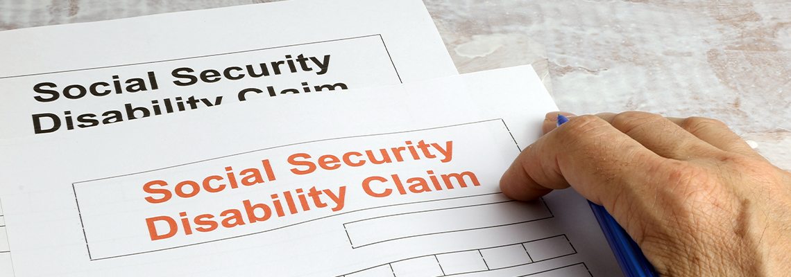 Form to fill out for requesting disability insurance Man's hand writing with pen