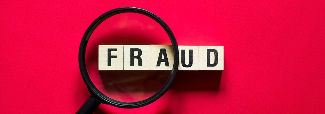 Fraud word concept on cubes with magnifying glass