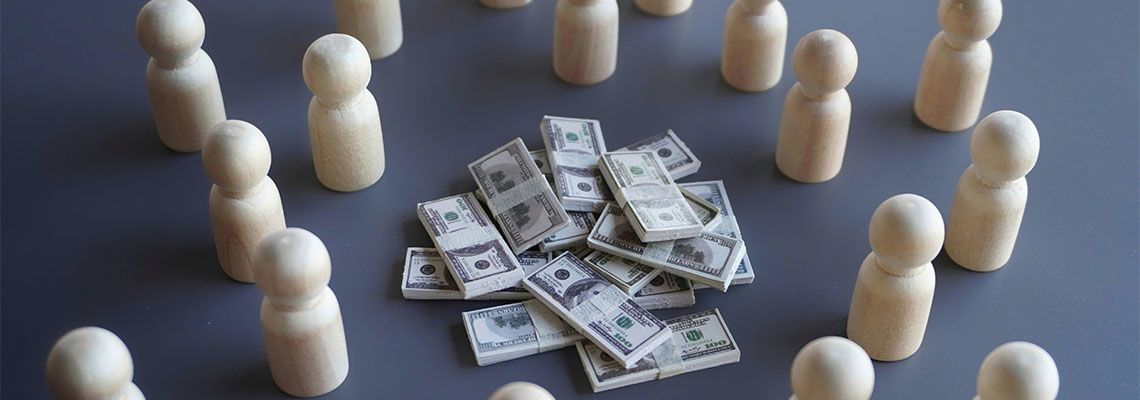 Group of wooden dolls and stack of money