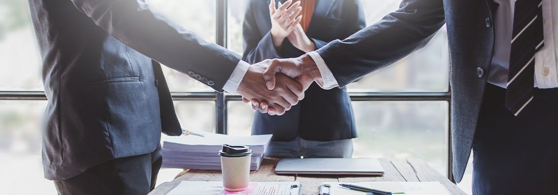 Businessmen shaking hands after successful Merger and Acquisition agreement