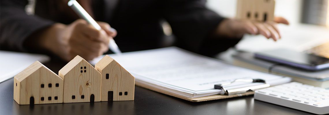 House model and real estate agent working on contract paper