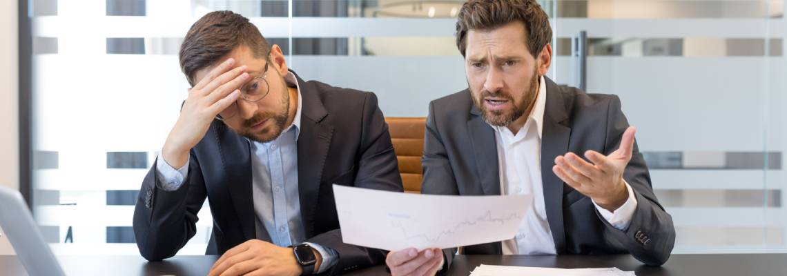 Two businessmen frustrated discussing financial report