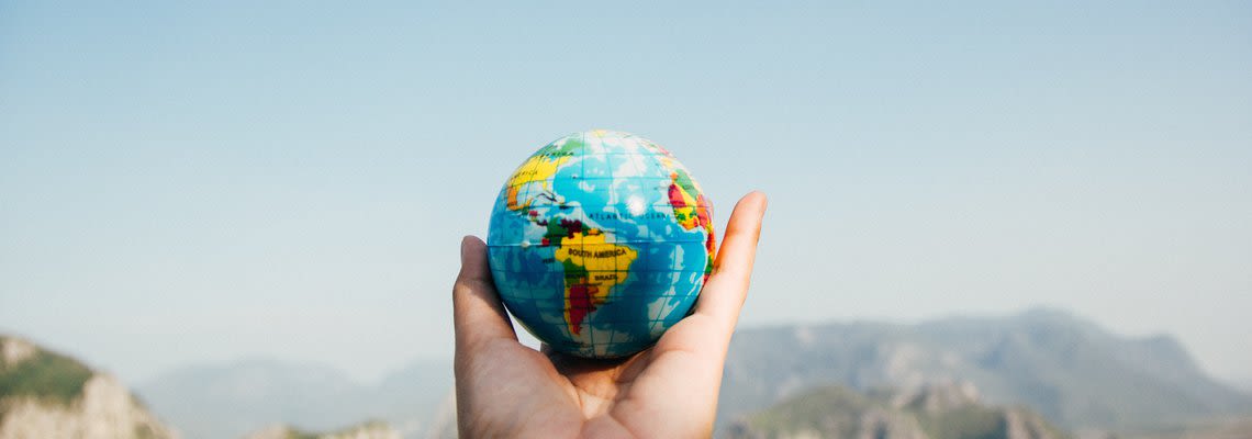 person holding a small globe