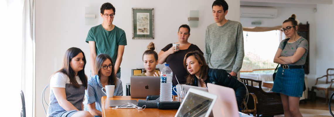 group of people watching a laptop