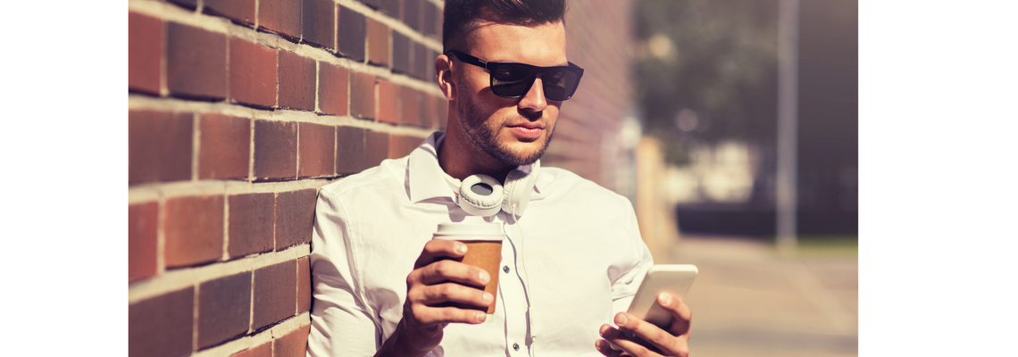 man holding coffee and his phone