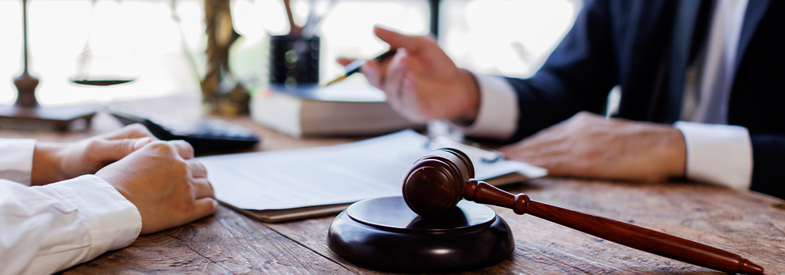 Client and lawyer discussing legal matters at a desk with a gavel