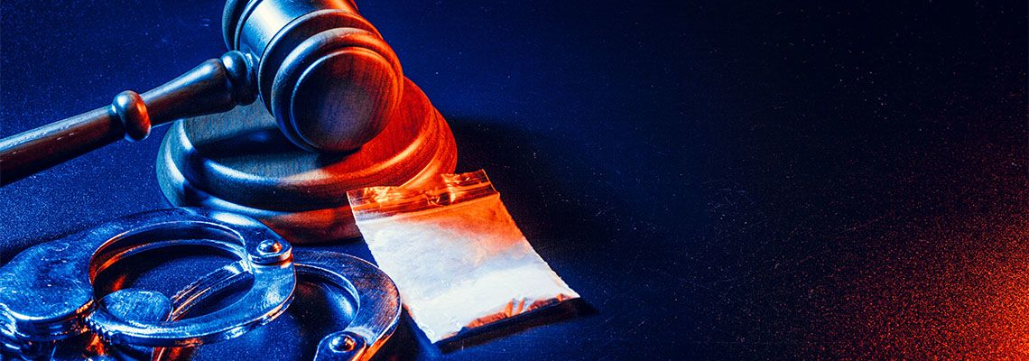 Judge gavel, handcuffs with white powder bag