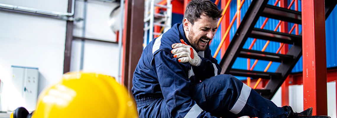 Worker with injured shoulder in floor