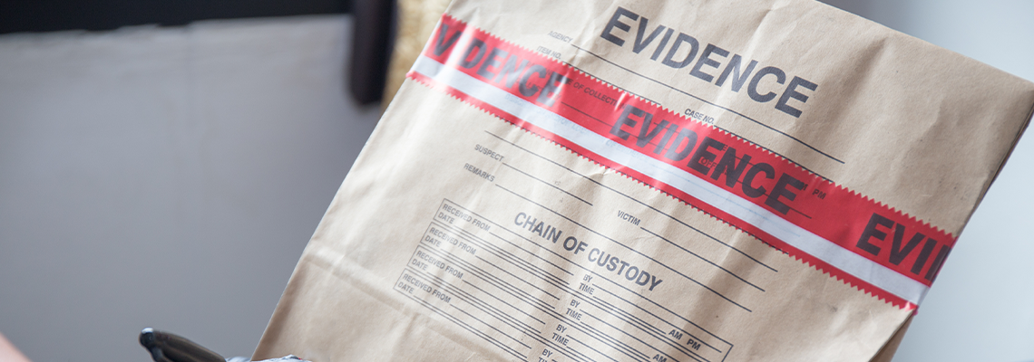 Hand in Glove Writing on Evidence Bag and Seal by Red Tape