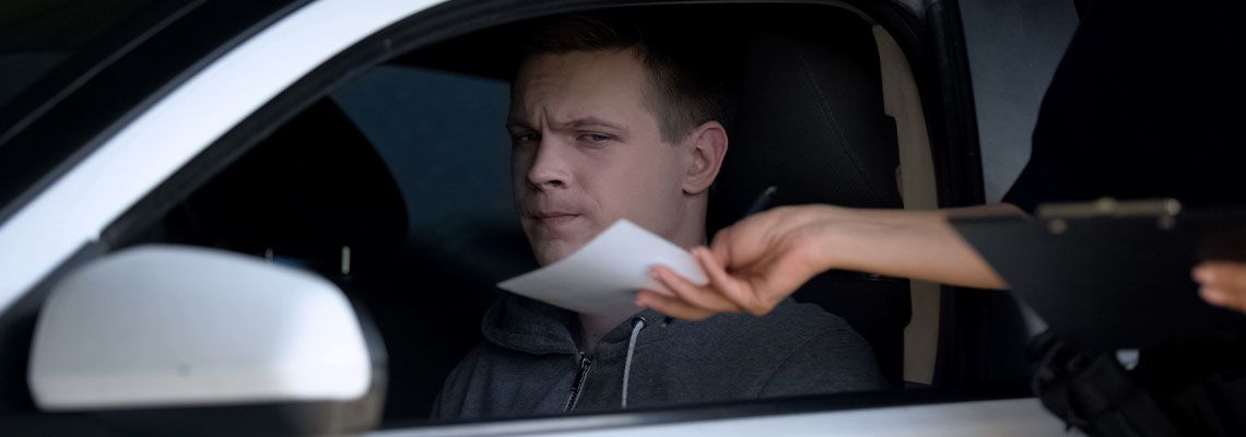 Police woman giving fine receipt to driver on road