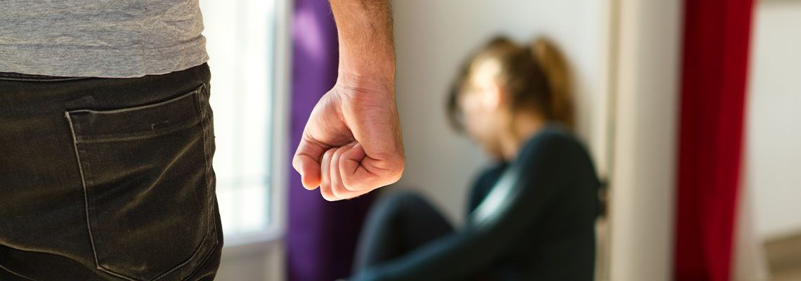 Man with closed fist and scared women in background