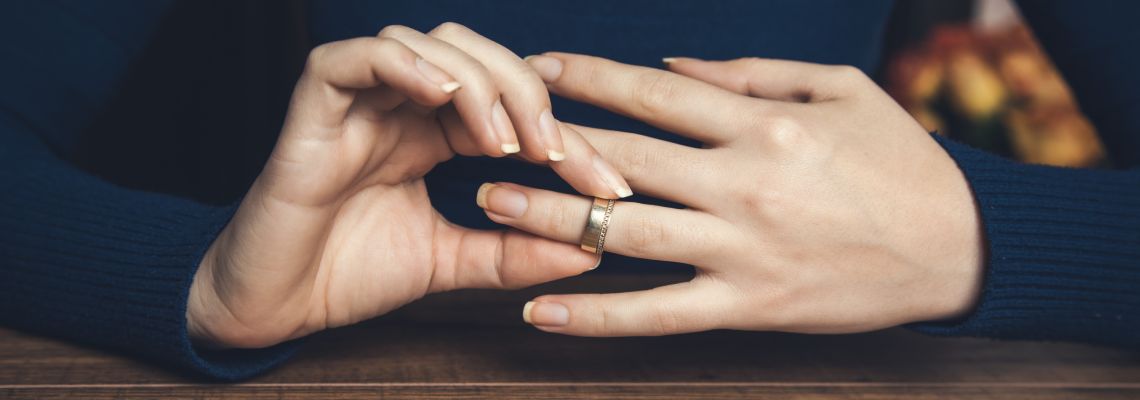 Women removing wedding ring from hand