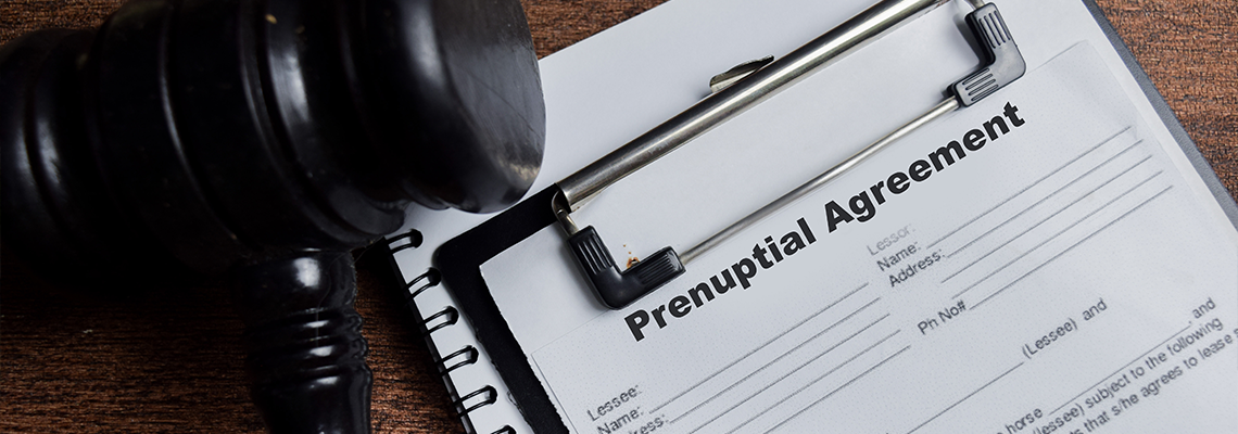 Concept of prenuptial agreement contract write on clipboard isolated on Wooden Table