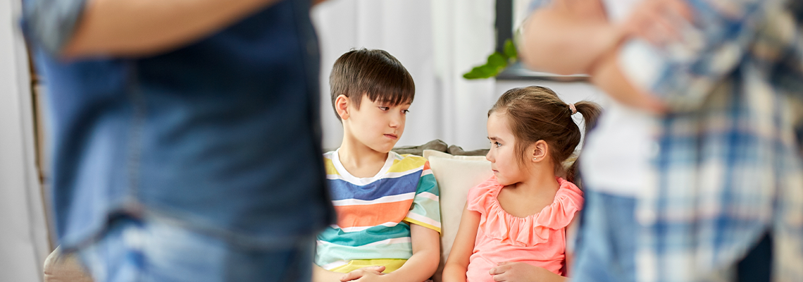 Sad children watching their parents quarreling at home