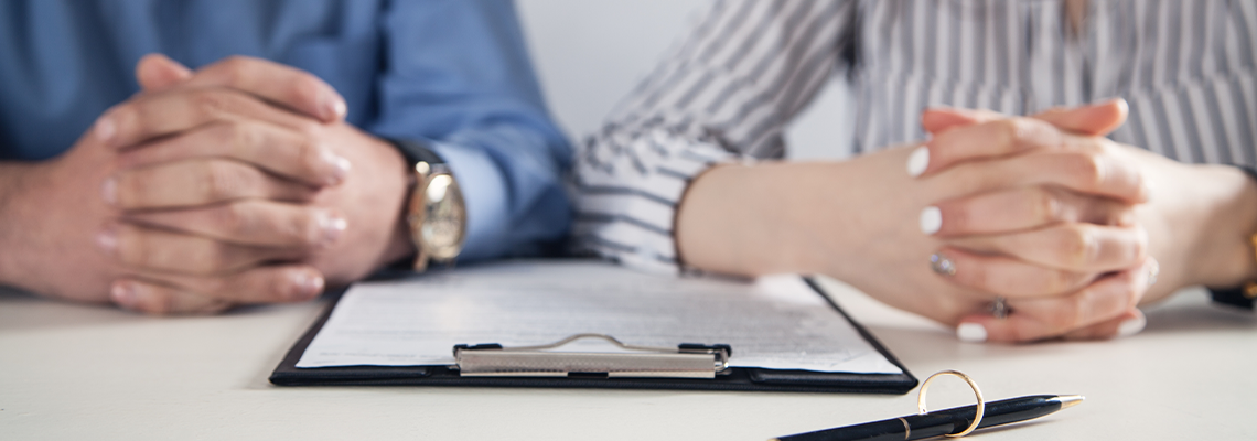 Couple with Divorce Contract and Ring on Desk