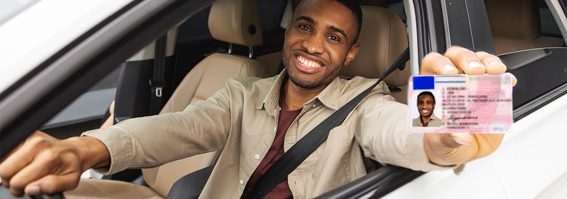 Happy man showing his driving license