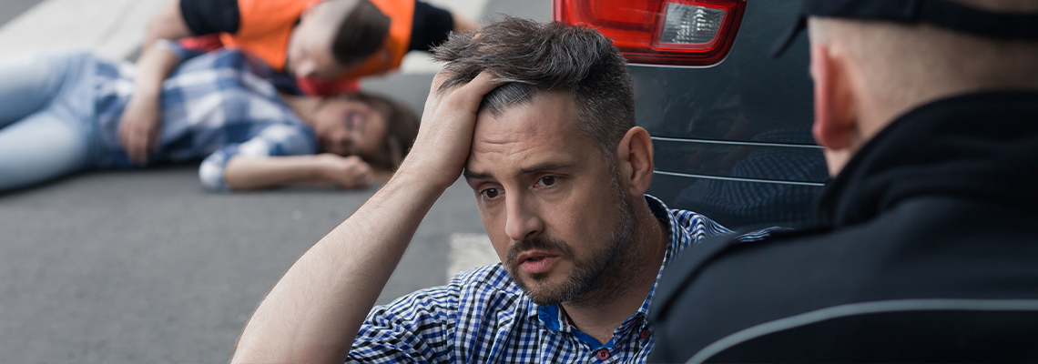 Stressed driver talking with a policeman after accident
