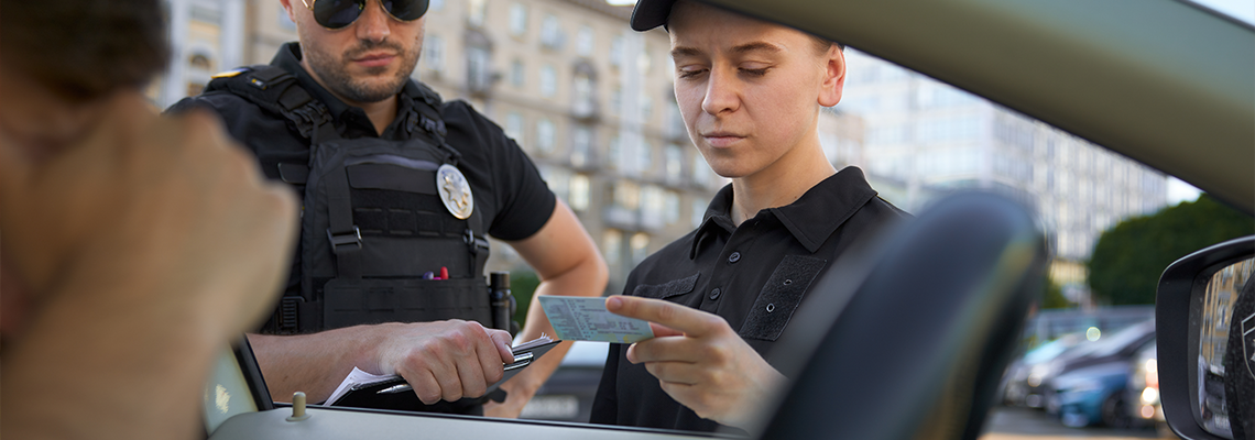 Police officers checking driving license of male driver violated speed traffic rules