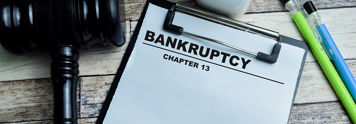 Chapter 13 Bankruptcy write on paperwork isolated on wooden background