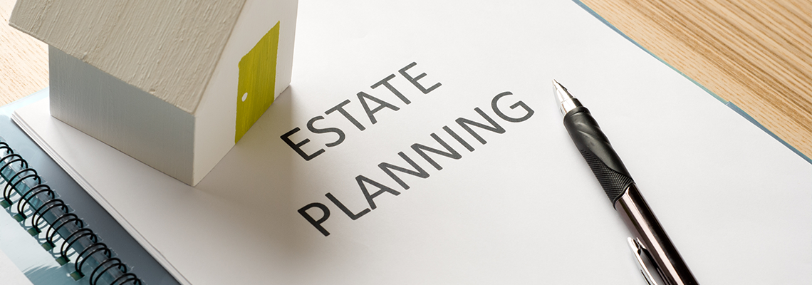 Estate planning note with pen and house model