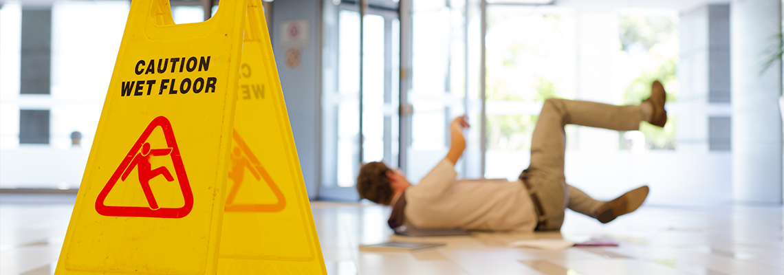 Businessman slipping on wet office floor and fell down