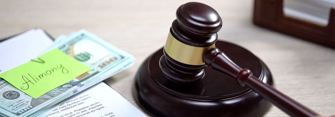 Alimony notes on dollar bills and gavel on table